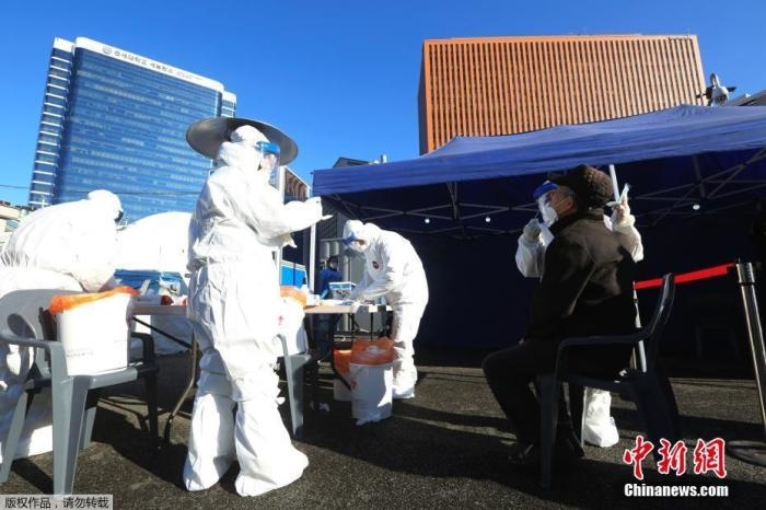 資料圖：韓國(guó)首爾，醫(yī)務(wù)人員對(duì)市民進(jìn)行新冠病毒檢測(cè)。