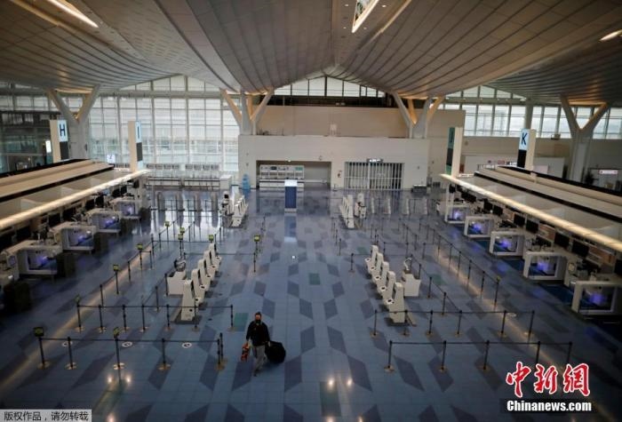 資料圖：日本東京，東京國(guó)際機(jī)場(chǎng)，一名乘客在國(guó)際航班航站樓的登機(jī)區(qū)。