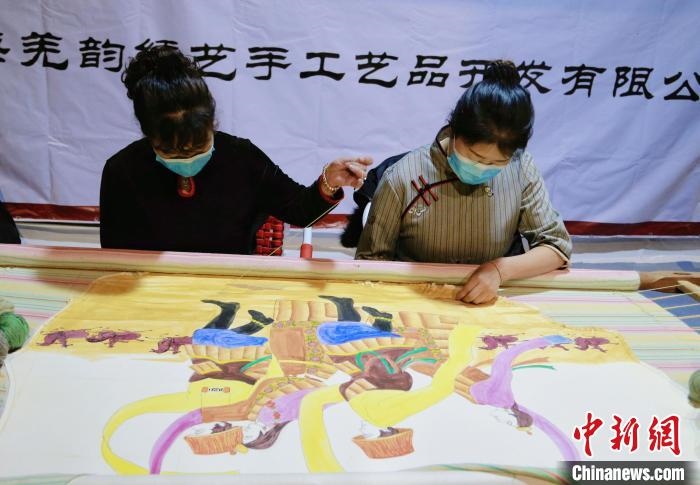 圖為皮繡藝人在市集上“秀”指尖技藝。　馬銘言 攝