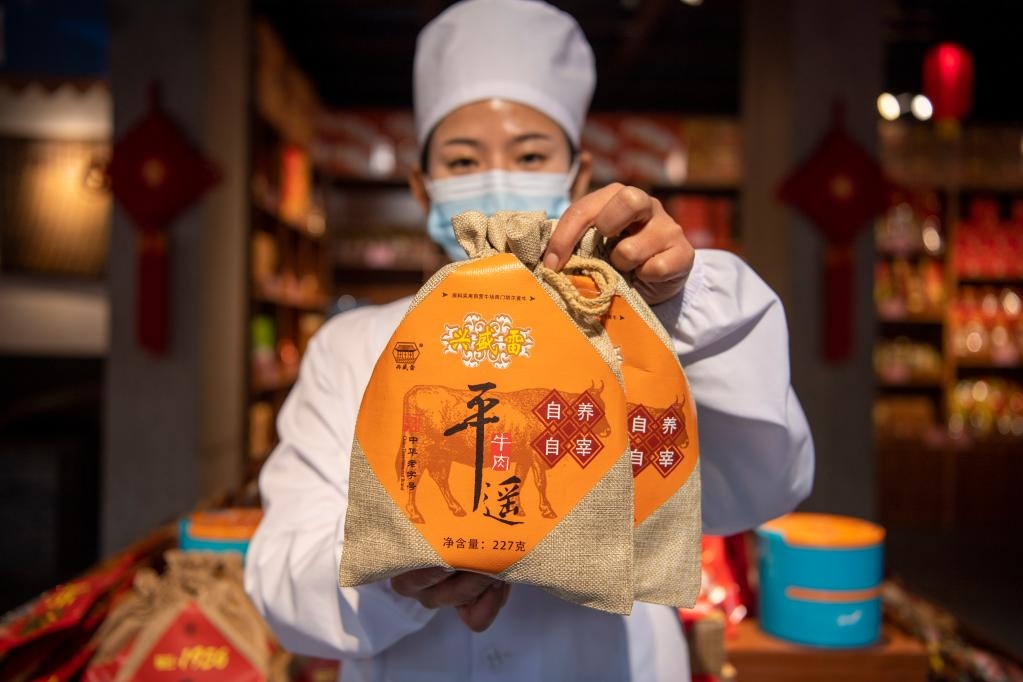 1月27日，在平遙古城南大街的一家平遙牛肉店內(nèi)，工作人員展示一款牛肉產(chǎn)品。新華社記者 楊晨光 攝