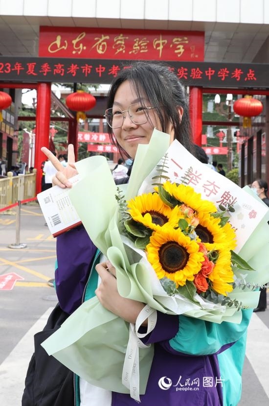 6月7日高考首日，山東67萬(wàn)考生走進(jìn)考場(chǎng)，拼搏逐夢(mèng)。在山東省實(shí)驗(yàn)中學(xué)考點(diǎn)，考生進(jìn)考場(chǎng)前手捧向日葵花拍照留念，寓意“一舉奪魁”。人民網(wǎng)記者 劉祺攝