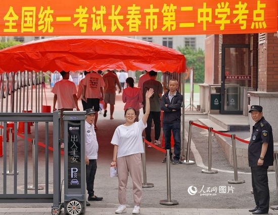6月7日，在長(zhǎng)春市第二中學(xué)考點(diǎn)，一名考生信心滿滿進(jìn)入考場(chǎng)，并與家長(zhǎng)揮手致意。人民網(wǎng)記者 李洋攝