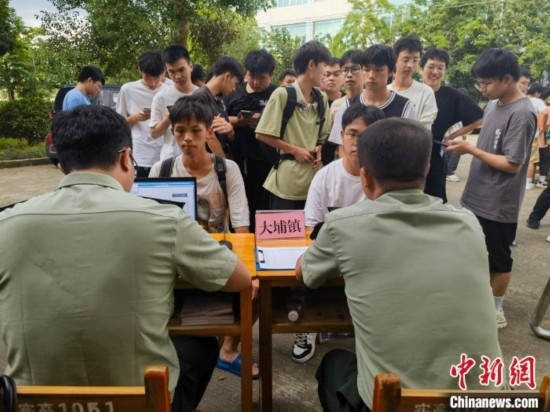 專武干部在發(fā)放兵役登記證。韋碩 攝