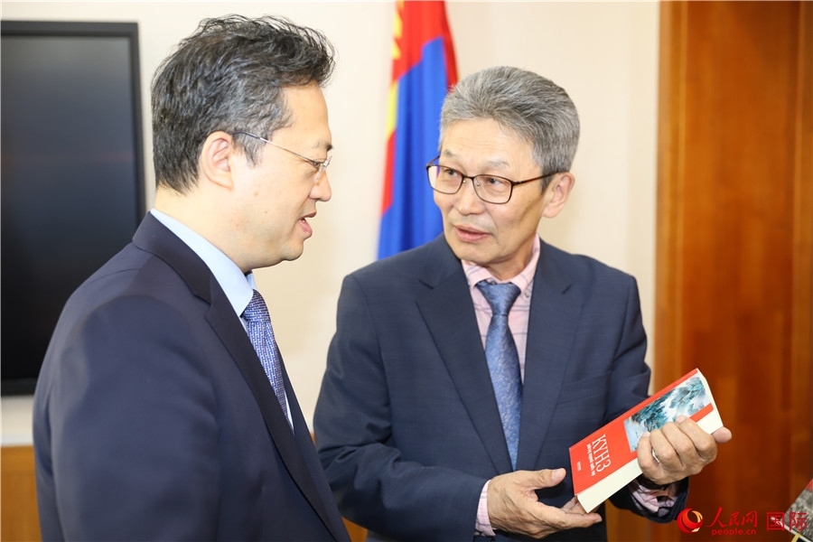 其米德策耶（右一）向李峙介紹翻譯成果。人民網(wǎng)記者 霍文攝