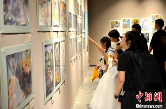 圖為家長帶著孩子參觀展覽。呂明 攝