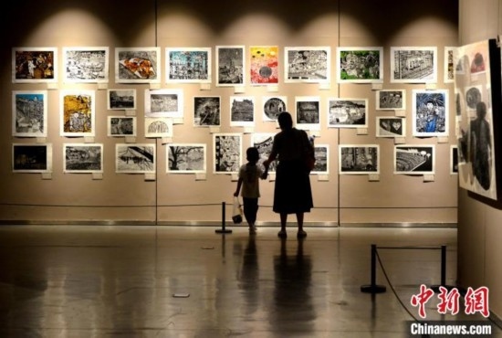 圖為家長帶著孩子參觀展覽。呂明 攝