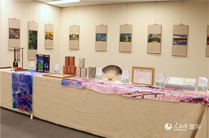 現(xiàn)場展出的馮學敏攝影作品與湖州市特色工藝品。（人民網(wǎng) 許可攝）