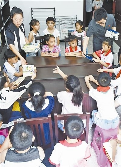  圖④：法院干警為留守兒童發(fā)放暑假讀物。