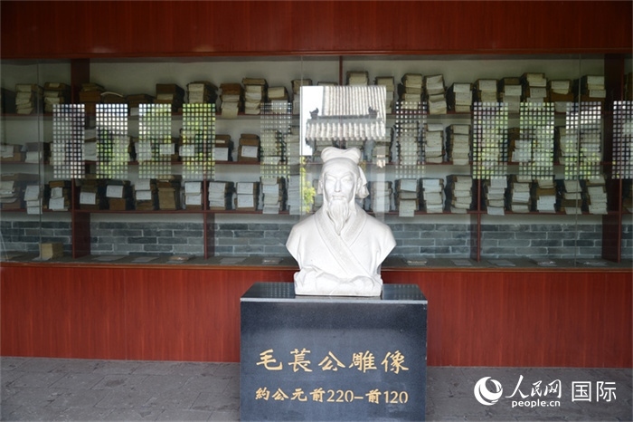 河間詩經(jīng)齋毛萇雕像。雕像后書櫥中陳列的是歷代各版本《詩經(jīng)》及譯本。 人民網(wǎng) 趙昭攝