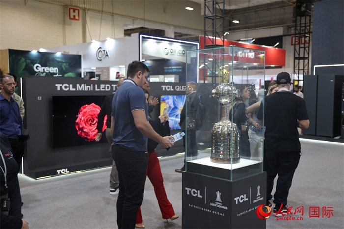 參觀者在TCL展臺前觀看南美解放者杯獎杯，據(jù)介紹，TCL是南美解放者杯（2023—2026賽季）全球官方合作伙伴。（人民網(wǎng)記者 時元皓攝）