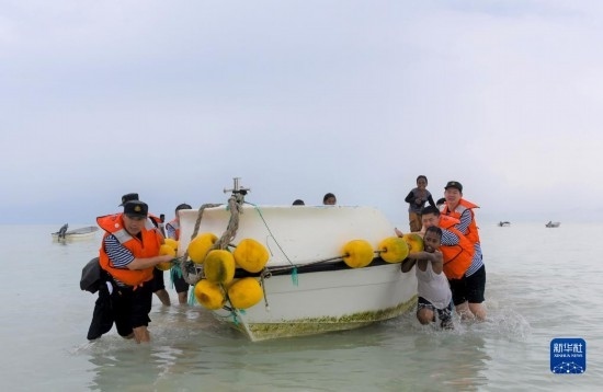 7月21日，中國海軍“和平方舟”號(hào)醫(yī)院船醫(yī)護(hù)人員涉水登島，前往基里巴斯一診療點(diǎn)。新華社記者 黎云 攝