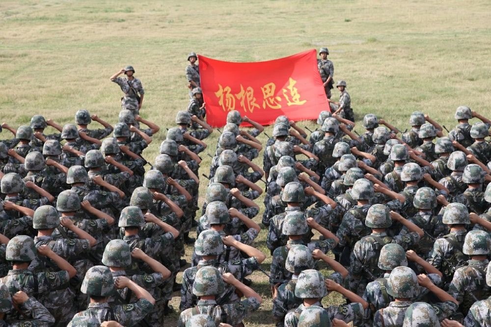 ↑“楊根思連”官兵執(zhí)行任務(wù)前向連旗宣誓（資料照片）。新華社發(fā)