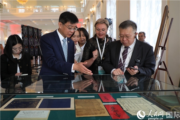 中俄圖書館論壇嘉賓共同參觀由俄羅斯國(guó)立列寧圖書館舉辦的館藏中國(guó)古籍善本圖書展。人民網(wǎng)記者 隋鑫攝）