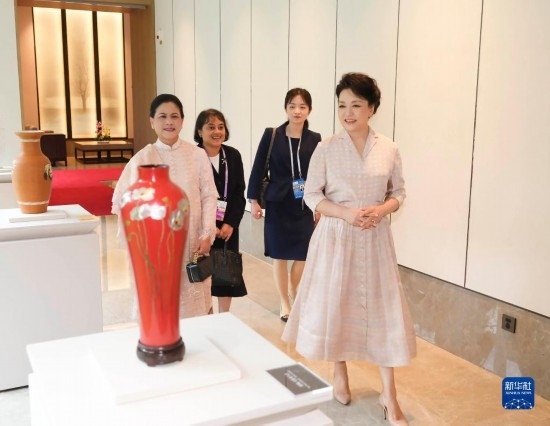 7月27日下午，國(guó)家主席習(xí)近平夫人彭麗媛在四川成都會(huì)見(jiàn)陪同印度尼西亞總統(tǒng)佐科來(lái)華出席第31屆世界大學(xué)生夏季運(yùn)動(dòng)會(huì)開(kāi)幕式并訪華的總統(tǒng)夫人伊莉亞娜。這是彭麗媛和伊莉亞娜欣賞成都特色非遺工藝品。新華社記者 丁林 攝