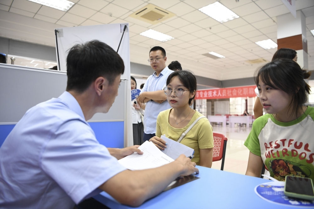 2023年7月29日，“揚(yáng)就業(yè)之帆，啟夢(mèng)想之旅”2023年寧夏（銀川）離校未就業(yè)高校畢業(yè)生招聘會(huì)在寧夏（銀川）人力資源服務(wù)產(chǎn)業(yè)園舉行。求職者（右）在招聘會(huì)現(xiàn)場(chǎng)與用人單位交流。新華社記者 馮開(kāi)華 攝