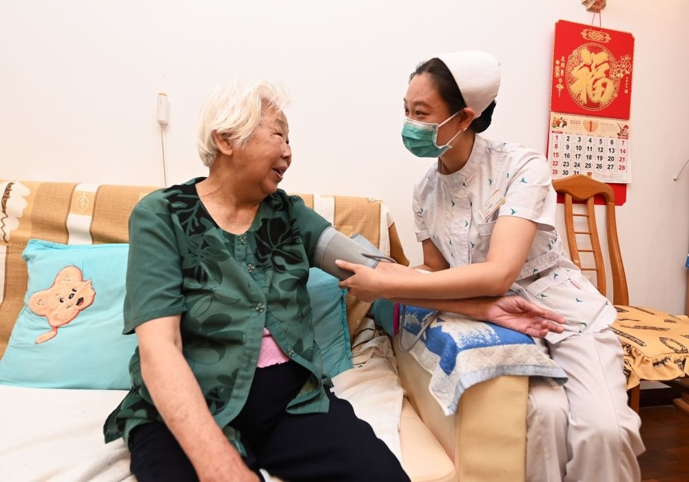 河北廊坊三河市燕達(dá)金色年華健康養(yǎng)護(hù)中心醫(yī)務(wù)人員為入住老人測(cè)量血壓（2023年7月20日攝）。新華社記者 朱旭東 攝