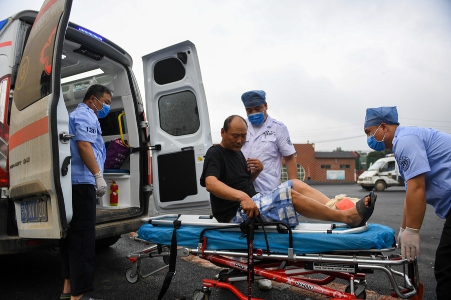 8月1日，在北京市門頭溝區(qū)妙峰山鎮(zhèn)妙峰山民族學校臨時安置點，北京急救中心工作人員在轉運一名受傷村民。新華社記者 鞠煥宗 攝