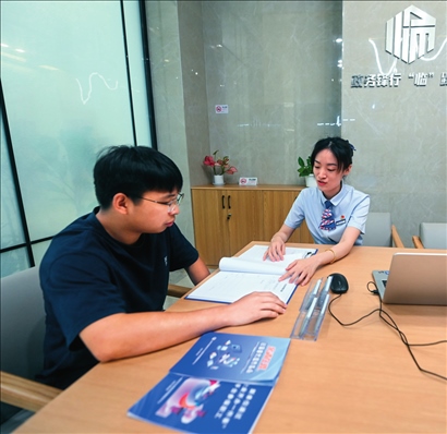 在杭州市臨安區(qū)政務(wù)服務(wù)中心的“為企服務(wù)中心”，黨員志愿者（右）解答企業(yè)主的疑問（2023年7月7日攝）。徐昱攝/本刊