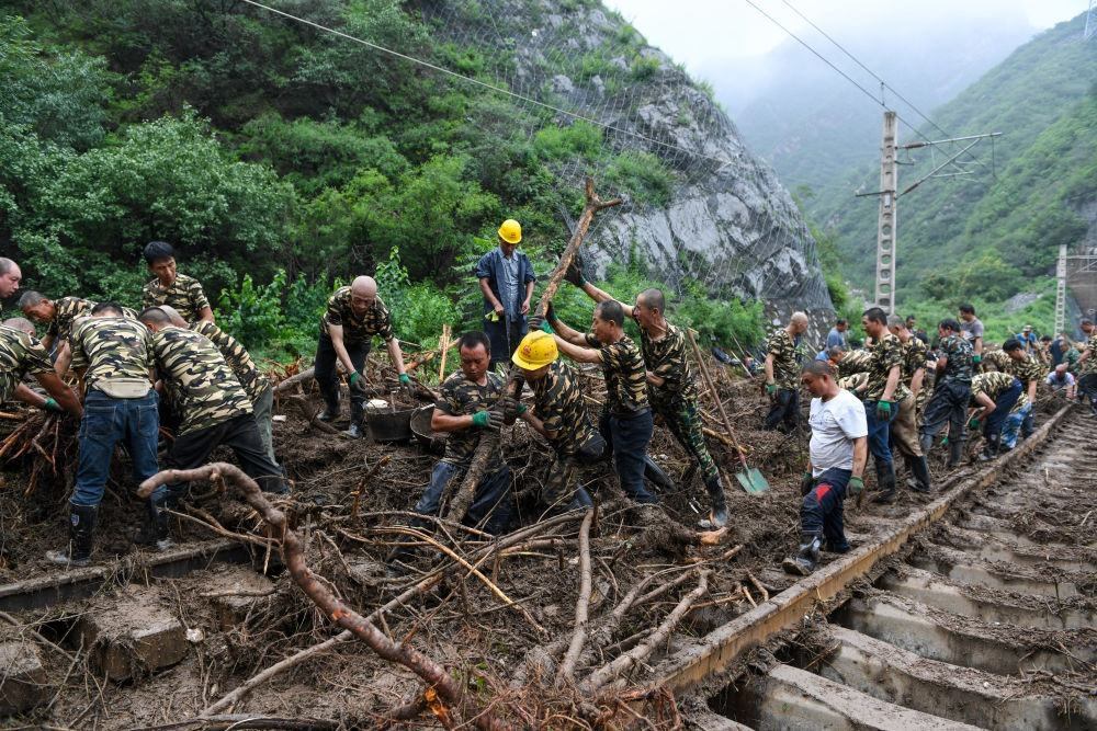 8月1日，在北京市門頭溝區(qū)水峪嘴村附近一段被阻斷的鐵路線上，中鐵六局工作人員在清理軌道上的雜物，全力恢復(fù)交通。新華社記者 鞠煥宗 攝