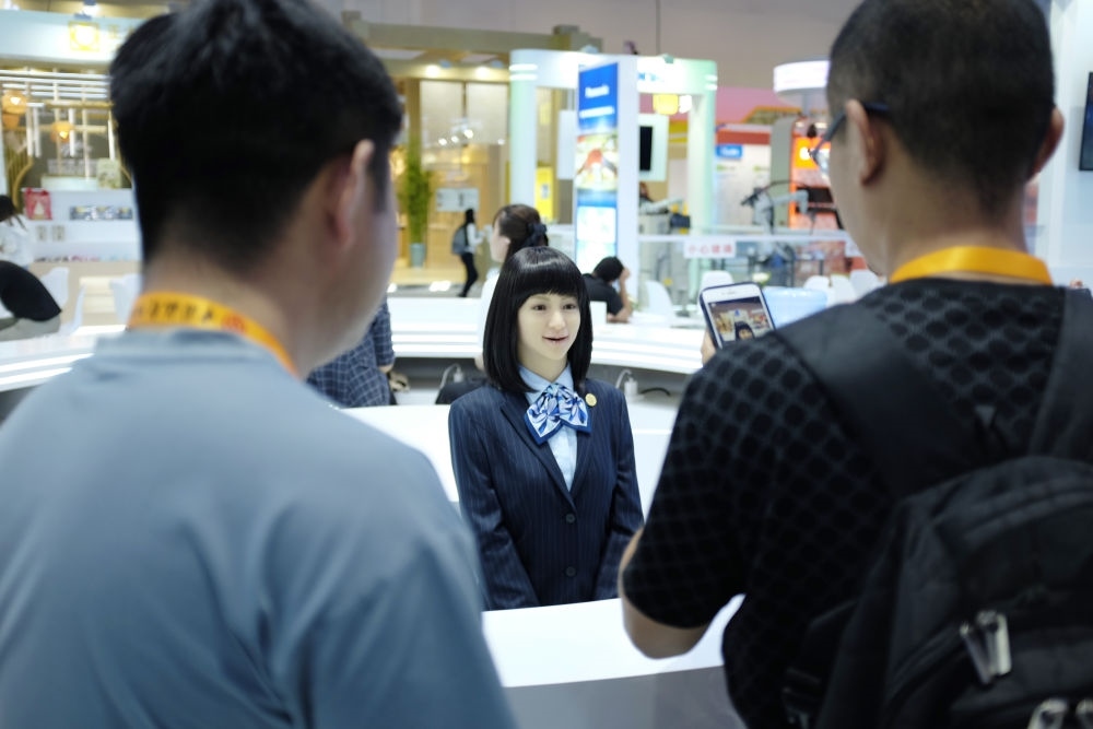 9月1日，媒體記者在國家會議中心與服務(wù)機(jī)器人互動。新華社記者 劉夢琪 攝