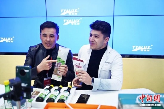 2023年3月，甘肅省慶陽(yáng)市環(huán)縣電商創(chuàng)業(yè)孵化基地內(nèi)，來(lái)自蘭州文理學(xué)院的塔吉克斯坦留學(xué)生正在協(xié)助主播直播帶貨當(dāng)?shù)剞r(nóng)特產(chǎn)品。李亞龍 攝