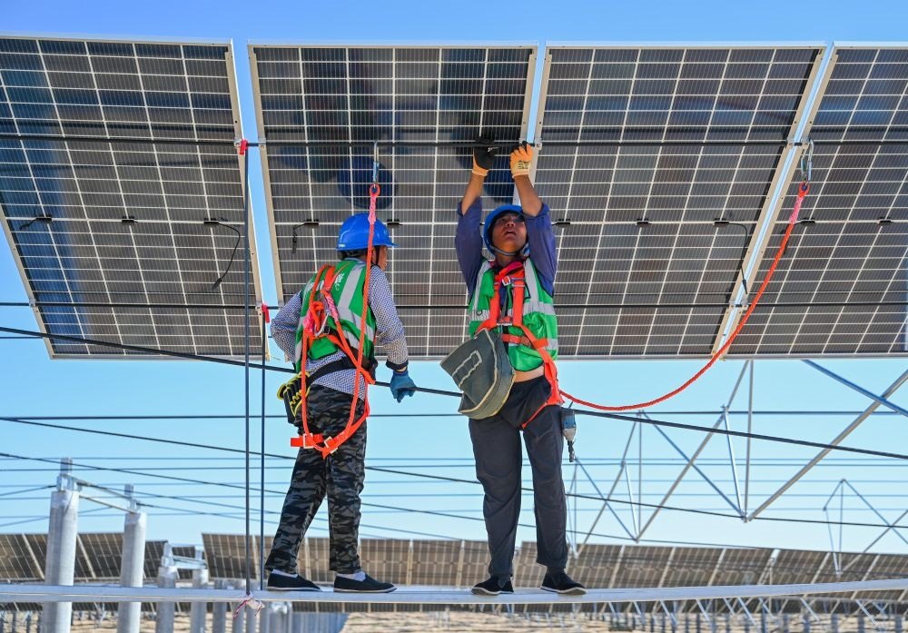 2023年7月22日，工人在位于內(nèi)蒙古杭錦旗庫布其沙漠億利生態(tài)示范區(qū)的蒙西基地庫布其200萬千瓦光伏治沙項目工地安裝光伏板。新華社記者 劉磊 攝