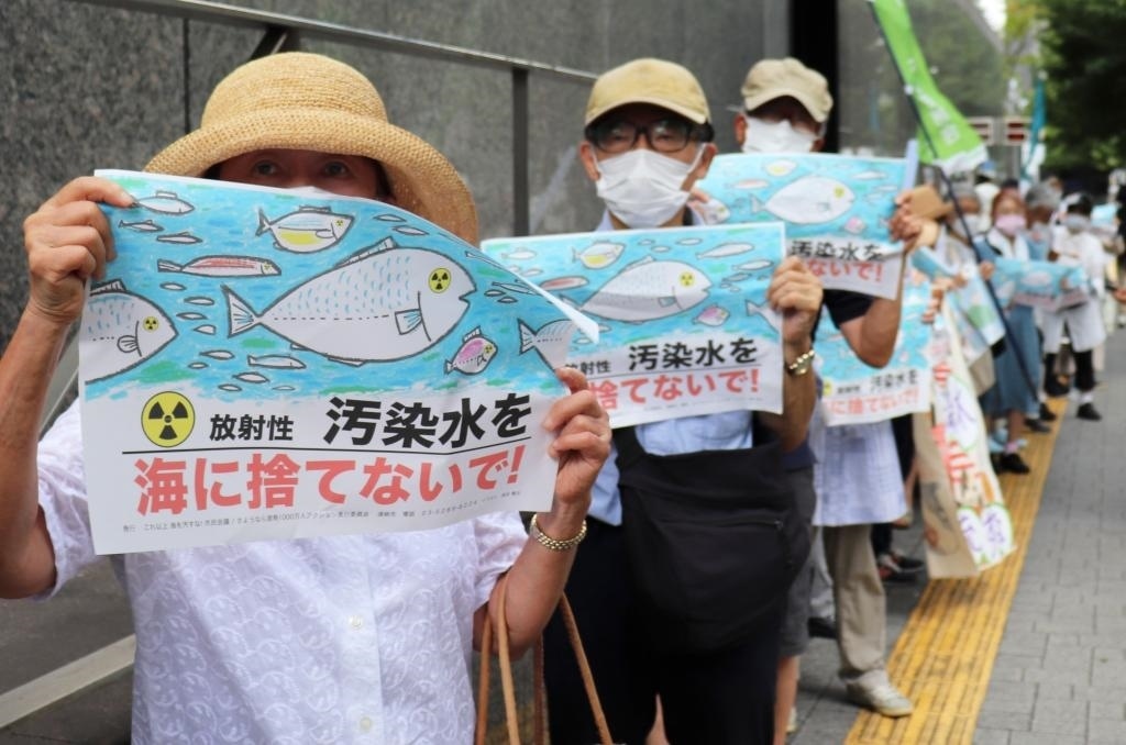 8月24日，日本民眾手持“不要將污染水扔進大?！钡葮苏Z在東京電力公司總部前集會，抗議日本政府和東電公司無視民意啟動核污染水排海。新華社記者楊光攝