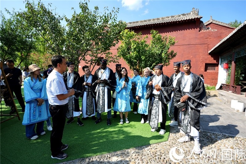 圖為選手們聽導(dǎo)游講解。人民網(wǎng) 盧鵬宇攝