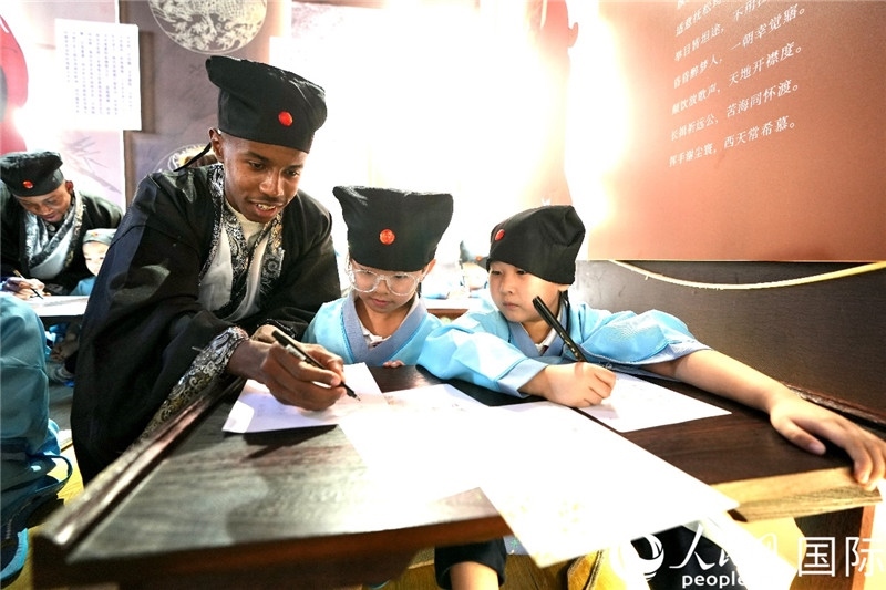 圖為選手與同學(xué)們一起寫書法。人民網(wǎng) 盧鵬宇攝