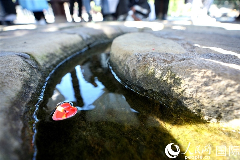 圖為水渠里流過的“桃心”蠟燭。人民網(wǎng) 盧鵬宇攝