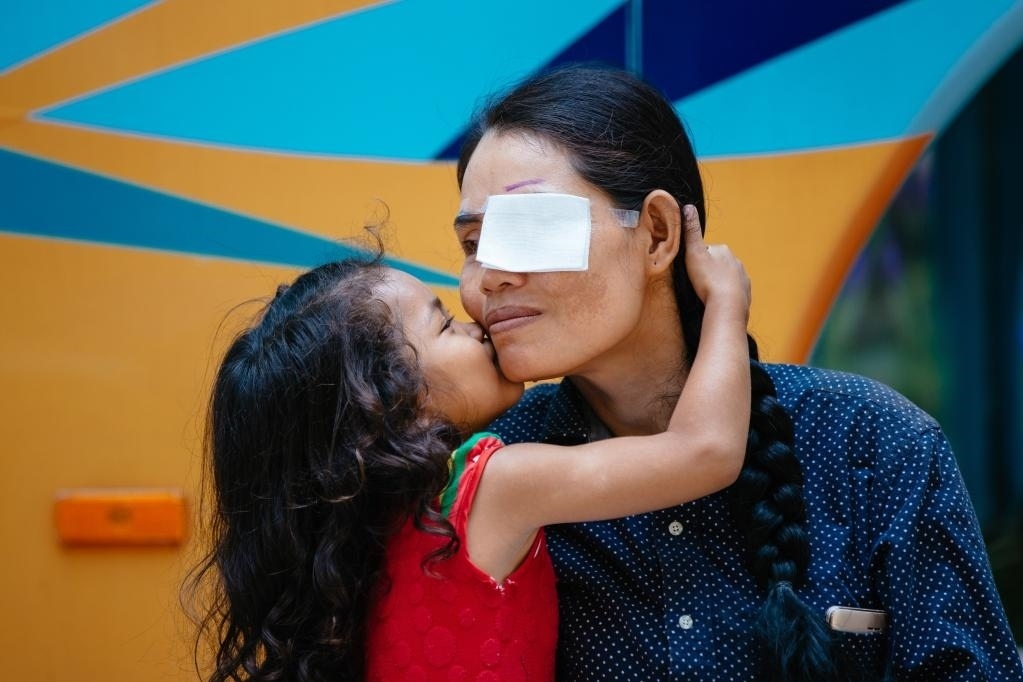 2019年3月15日，在柬埔寨磅湛省醫(yī)院，即將接受白內障手術的患者孫美樂接受女兒的親吻祝福。在接受了中國醫(yī)療隊的白內障義診手術后，她的視力逐步恢復，生活有了新的光明和希望。