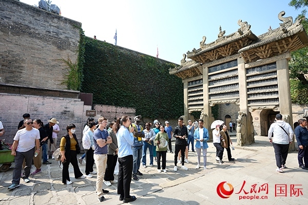 選手們認(rèn)真聆聽導(dǎo)游講解。人民網(wǎng) 盧鵬宇攝