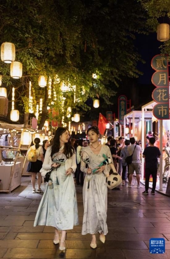 在成都寬窄巷子，兩位來(lái)自安徽的游客在新“十二月市”街區(qū)游覽（9月29日攝）。