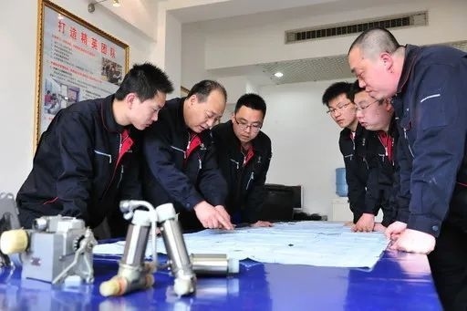 △李志強(qiáng)（左二）與班組成員在研究工作。