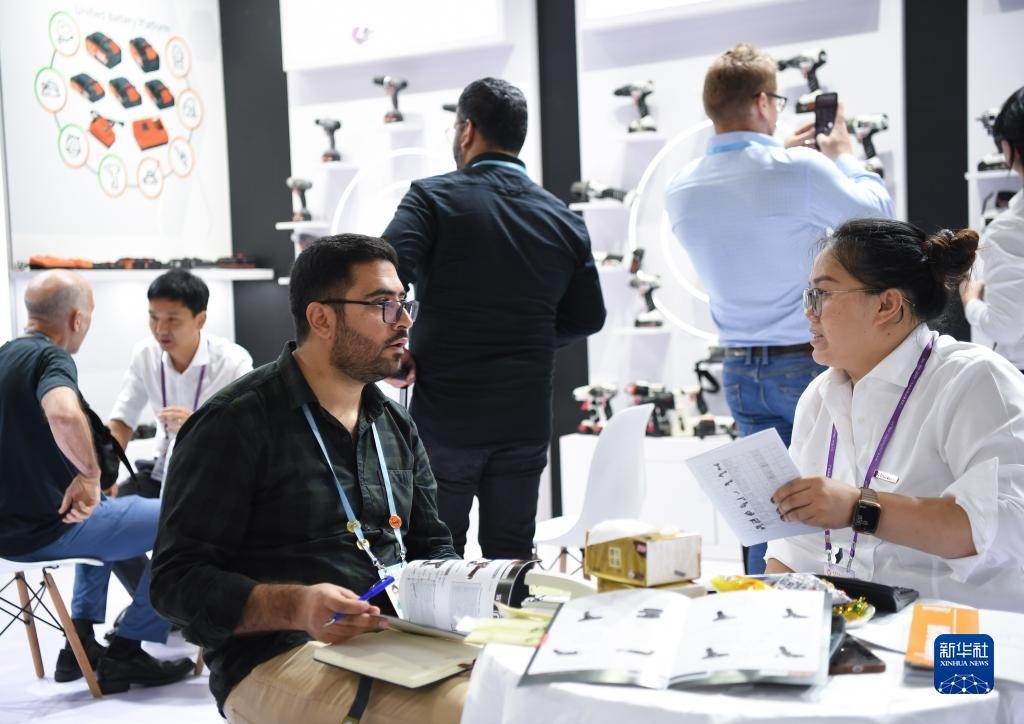 10月15日，在一家電動(dòng)工具展臺(tái)，外國(guó)采購(gòu)商在洽談業(yè)務(wù)。新華社記者 鄧華 攝
