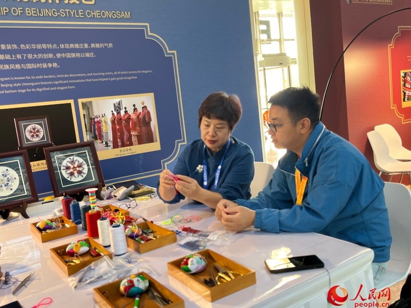 記者在新聞中心非遺傳承人展區(qū)進(jìn)行體驗(yàn)。人民網(wǎng)記者 杜燕飛攝