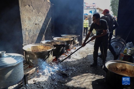 11月3日，在加沙地帶南部城市拉法，人們?cè)诿簹庵袛嗪笥貌窕鹱鲲?。新華社發(fā)（里澤克·阿卜杜勒賈瓦德攝）