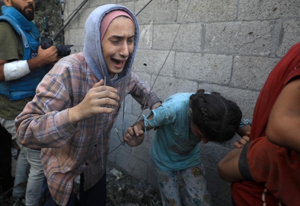 11月6日，人們從加沙地帶中部地區(qū)一處被炸難民營逃離。新華社發(fā)（亞西爾·庫迪攝）