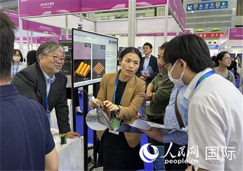 工作人員向參觀者介紹超級(jí)噴墨技術(shù)。（人民網(wǎng)記者 陳思攝）