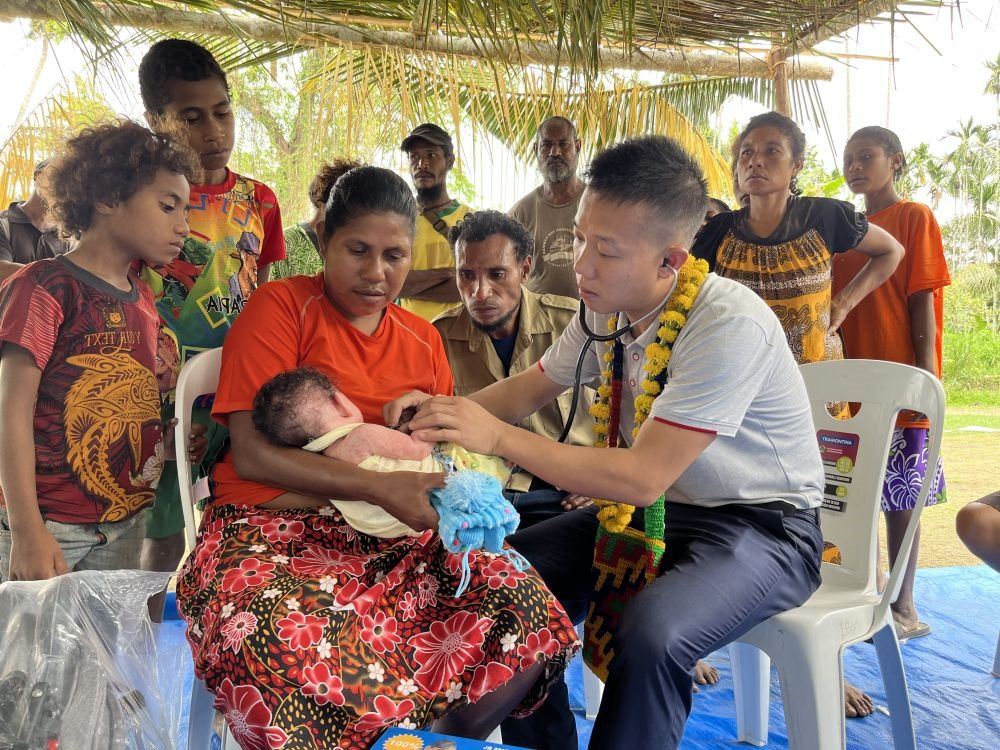 2023年8月5日，在巴布亞新幾內亞中央省的一個村莊里，第12批援巴新中國醫(yī)療隊副隊長、新生兒科副主任醫(yī)師劉振球為嬰兒泰樂聽診檢查。泰樂出生時患有重癥，一度生命垂危，經過劉振球與當?shù)蒯t(yī)護人員的救治最終痊愈。從2002年起，中國連續(xù)向巴新派出12批醫(yī)療隊，為提高巴新醫(yī)療衛(wèi)生水平作出積極貢獻。