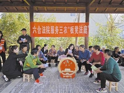  圖③：干警向附近農(nóng)戶解讀相關(guān)法律法規(guī)。