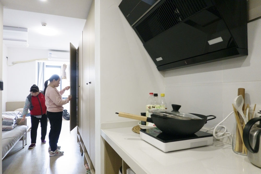 住戶在閔行區(qū)新時代城市建設(shè)者管理者之家收拾房間。