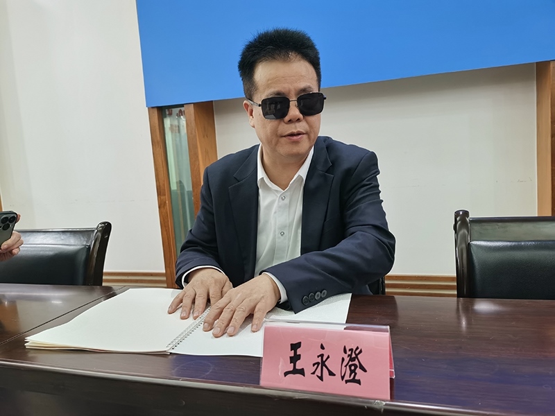 全國人大代表王永澄正在閱讀盲文版代表建議答復(fù)。本報(bào)記者 張 璁?dāng)z