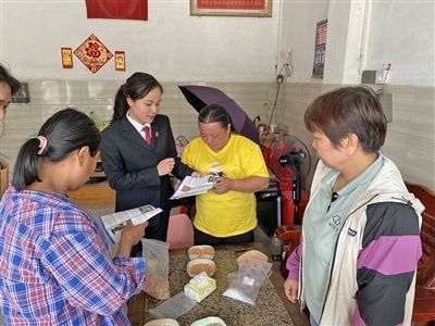  圖⑤：龍圩區(qū)法院法官到群眾家中開展法治宣傳。資料圖片