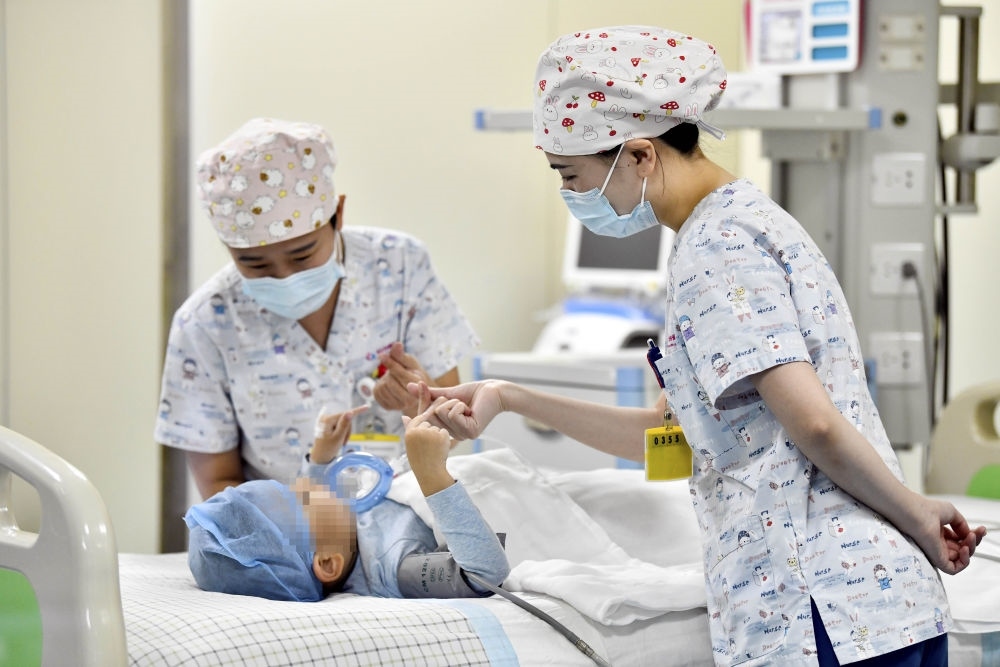 在山東省棗莊市婦幼保健院兒童ICU病房，醫(yī)護人員為完成靶向治療藥物諾西那生鈉的4歲脊髓性肌萎縮癥患兒加油鼓勁（2022年1月1日攝）。諾西那生鈉注射液是我國首個獲批治療脊髓性肌萎縮癥的進口藥物，2019年進入中國市場時，每針價格近70萬元。在2021年國家醫(yī)保目錄藥品談判中，以3.3萬元每針的價格進入新版醫(yī)保藥品目錄。新華社記者 郭緒雷 攝