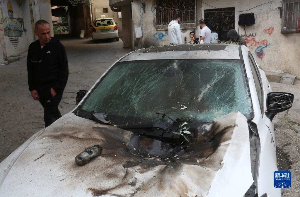 12月17日，在約旦河西岸城市圖勒凱爾姆附近的一處難民營，人們查看在沖突中損毀的車輛。新華社發(fā)（尼達爾·艾仕塔耶攝）