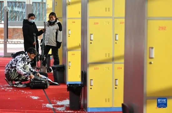 12月21日，游客在滑雪服務(wù)大廳整理滑雪裝備。