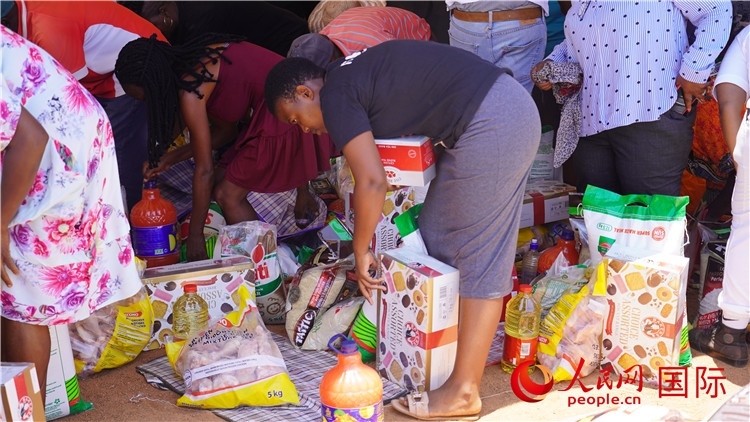 當(dāng)?shù)厣鐓^(qū)家庭領(lǐng)取物資。人民網(wǎng) 張茜攝