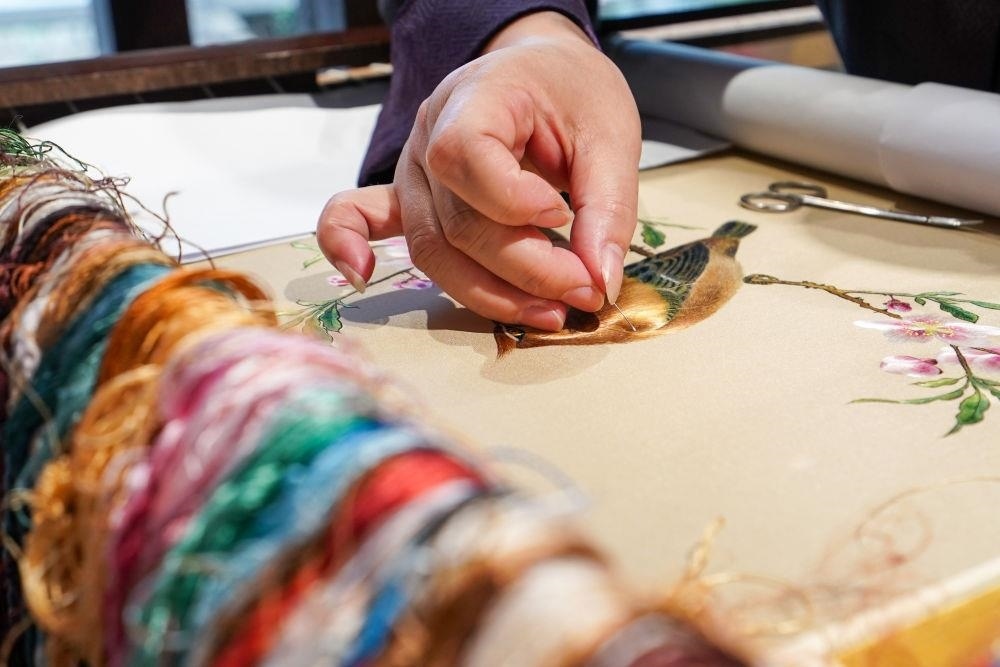 △2023年7月6日，盧建英在江蘇蘇州平江路的工作室內(nèi)刺繡。