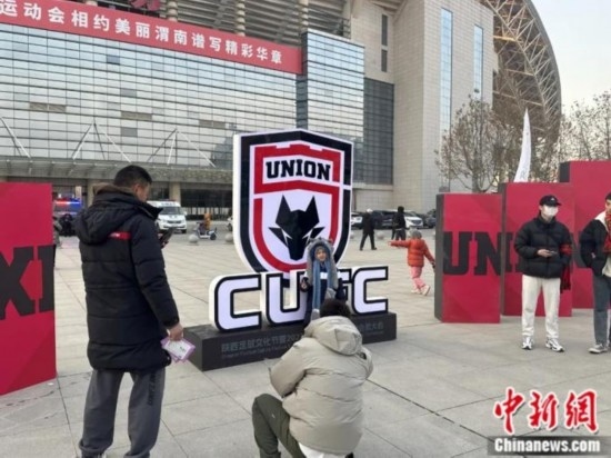 球迷們與隊(duì)徽合影。記者 卞立群 攝